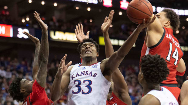 Mar 12, 2022; Kansas City, MO, USA; Kansas Jayhawks forward David McCormack (33) shoots the ball against Texas Tech Red Raiders forward Marcus Santos-Silva (14) and Texas Tech Red Raiders guard Davion Warren (2) in the second half at T-Mobile Center. Mandatory Credit: Amy Kontras-USA TODAY Sports